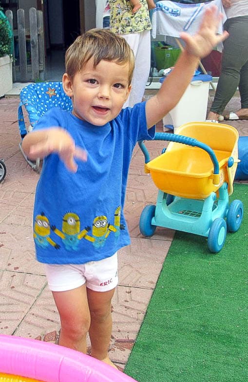 A young boy wearing a blue t-shirt with minions across the bottom. 
