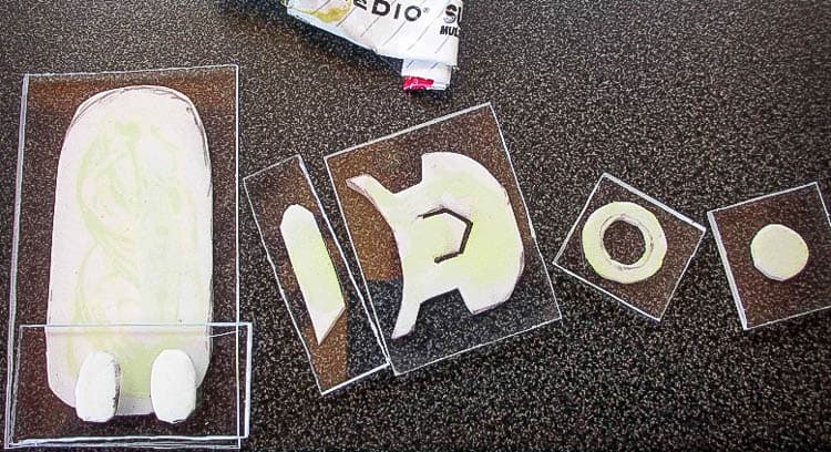 Making stamps by gluing craft foam shapes to transparent plastic squares and rectangles. 
