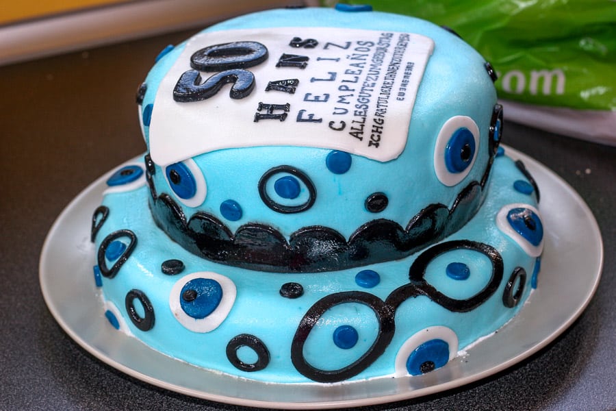 Side view of a fondant optometrist cake that is shiny from water condensation on top.