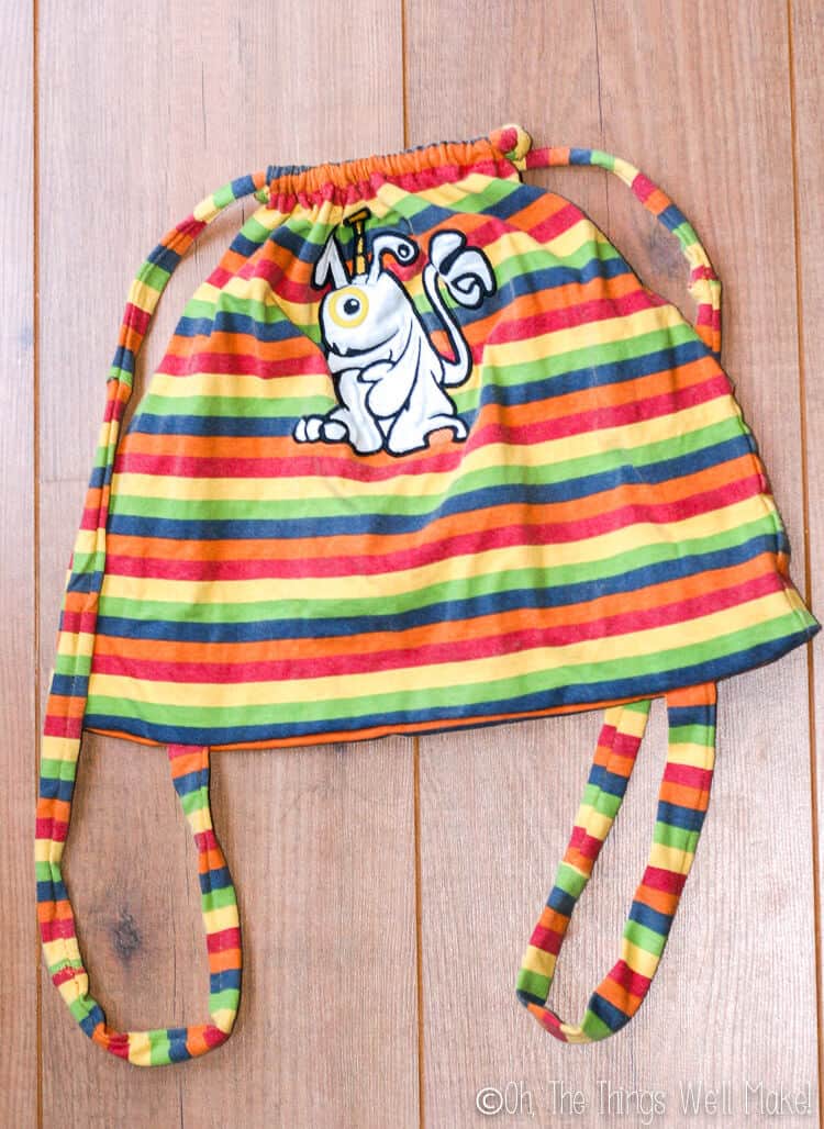 Top view of a finished drawstring backpack made from a baby shirt.