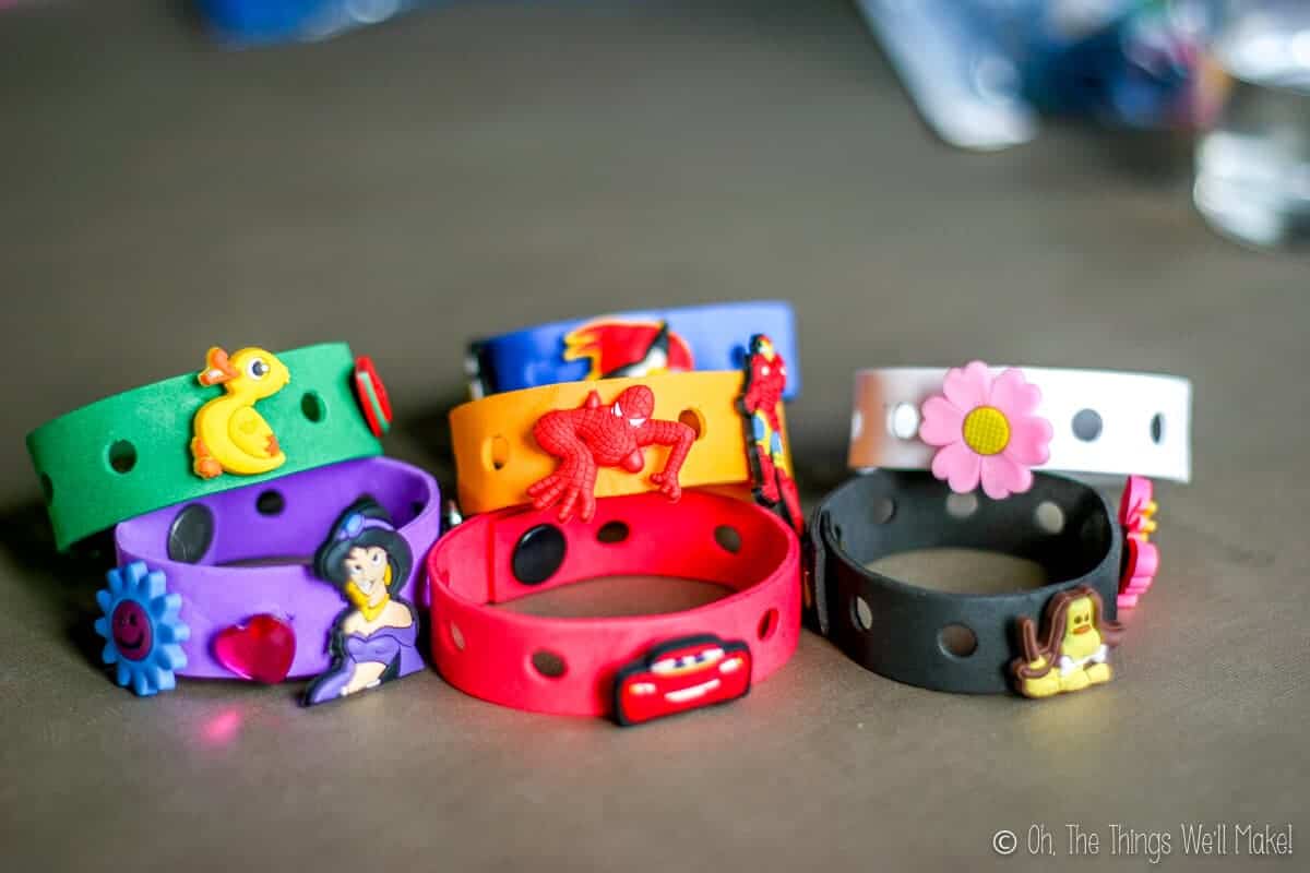 Close-up of homemade colorful craft foam bracelets in several colors with Crocs charms (Jibbitz) on them.