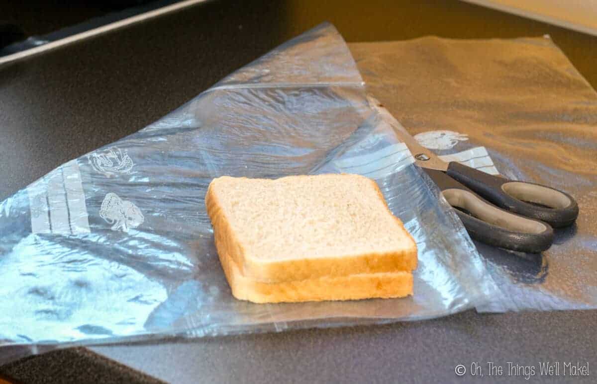 A sheet of fused plastic on a counter with two slices of sandwich bread on top.