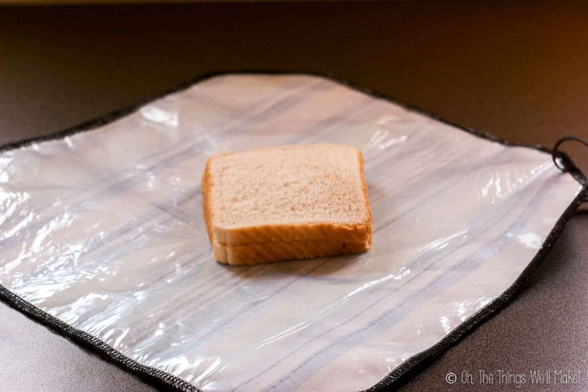 Side view of two slices of sandwich bread in center of an open sandwich wrap.