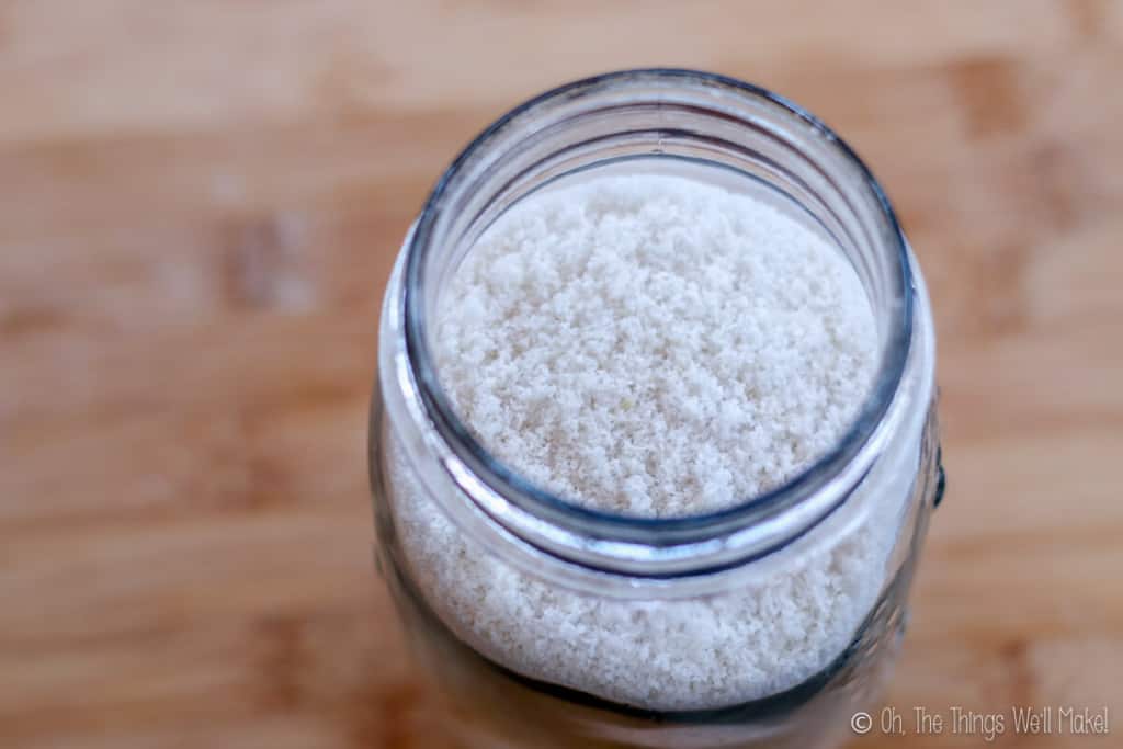 Top view of a glass jar full of white coconut flour.