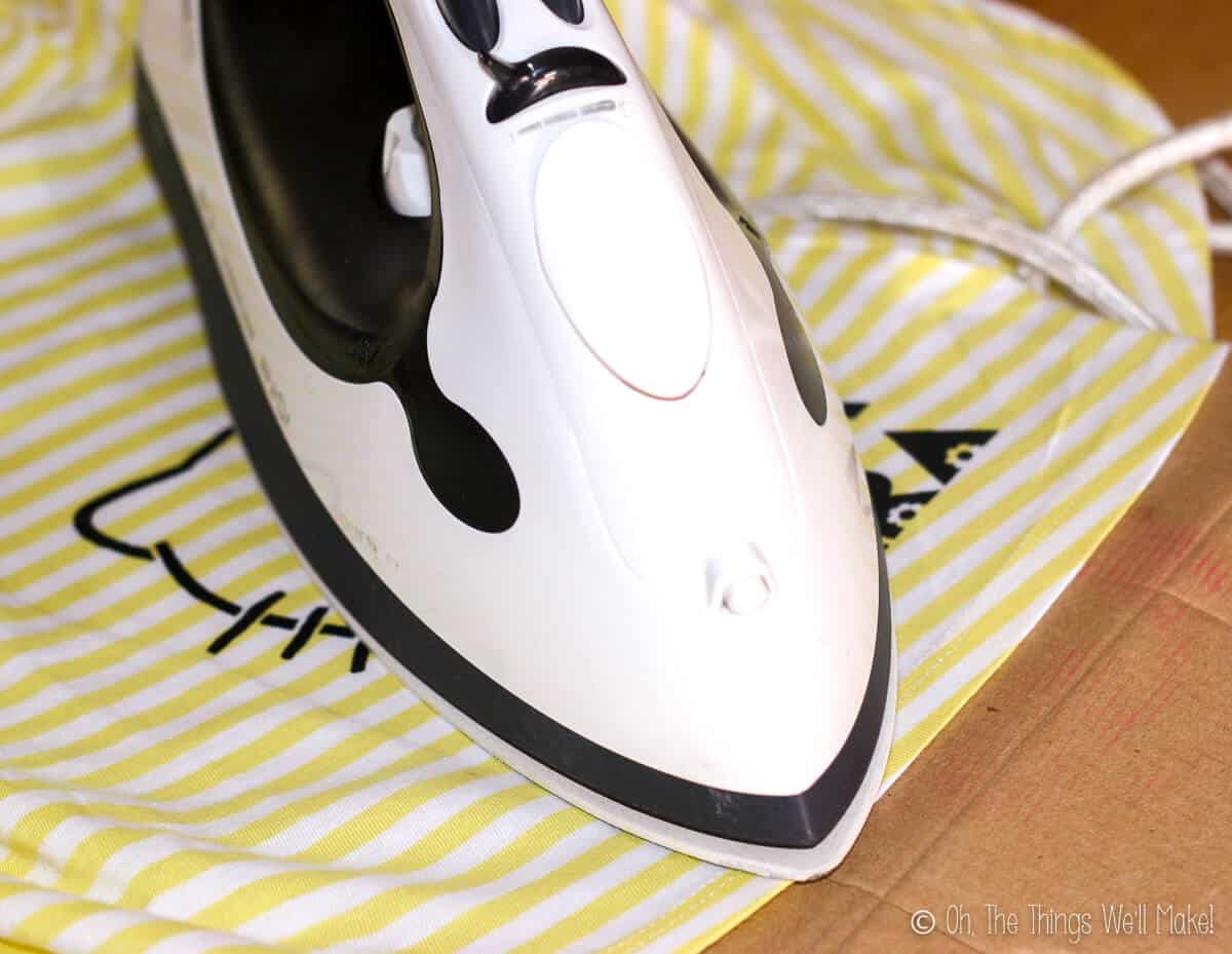 An iron over a painted Hello Kitty design on a yellow and white dress.