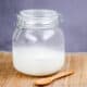 Large jar with home rendered lard and a wooden spoon in front of it.