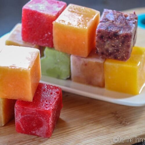 a rainbow of different colored frozen fruit ice cubes