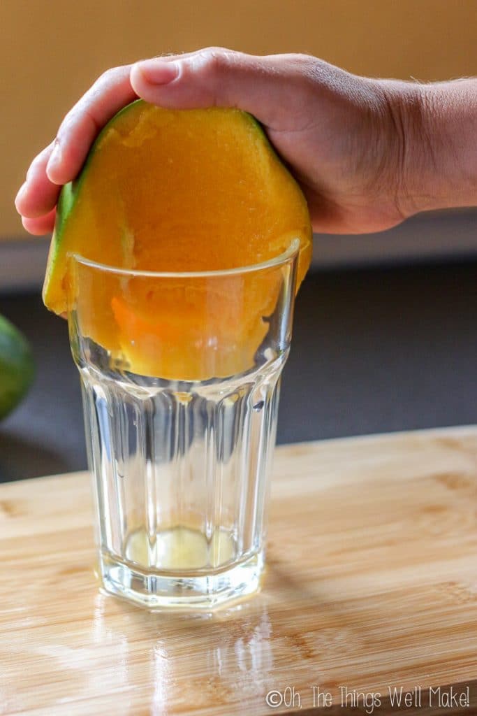 peeling a mango using the side of a glass