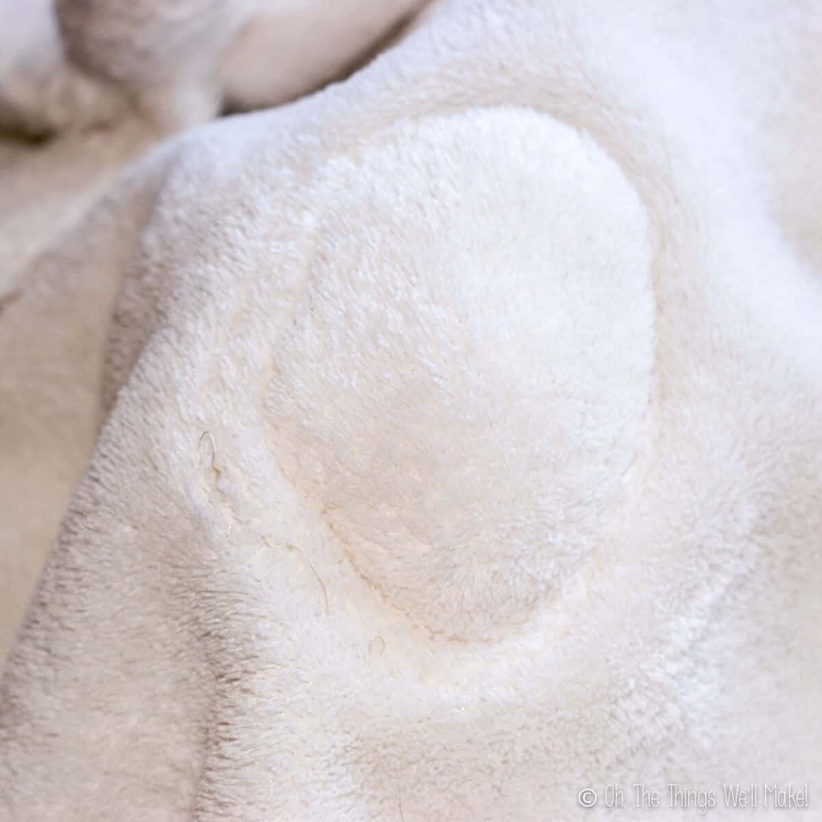 Close up of where the head has been sewn on the white blanket.