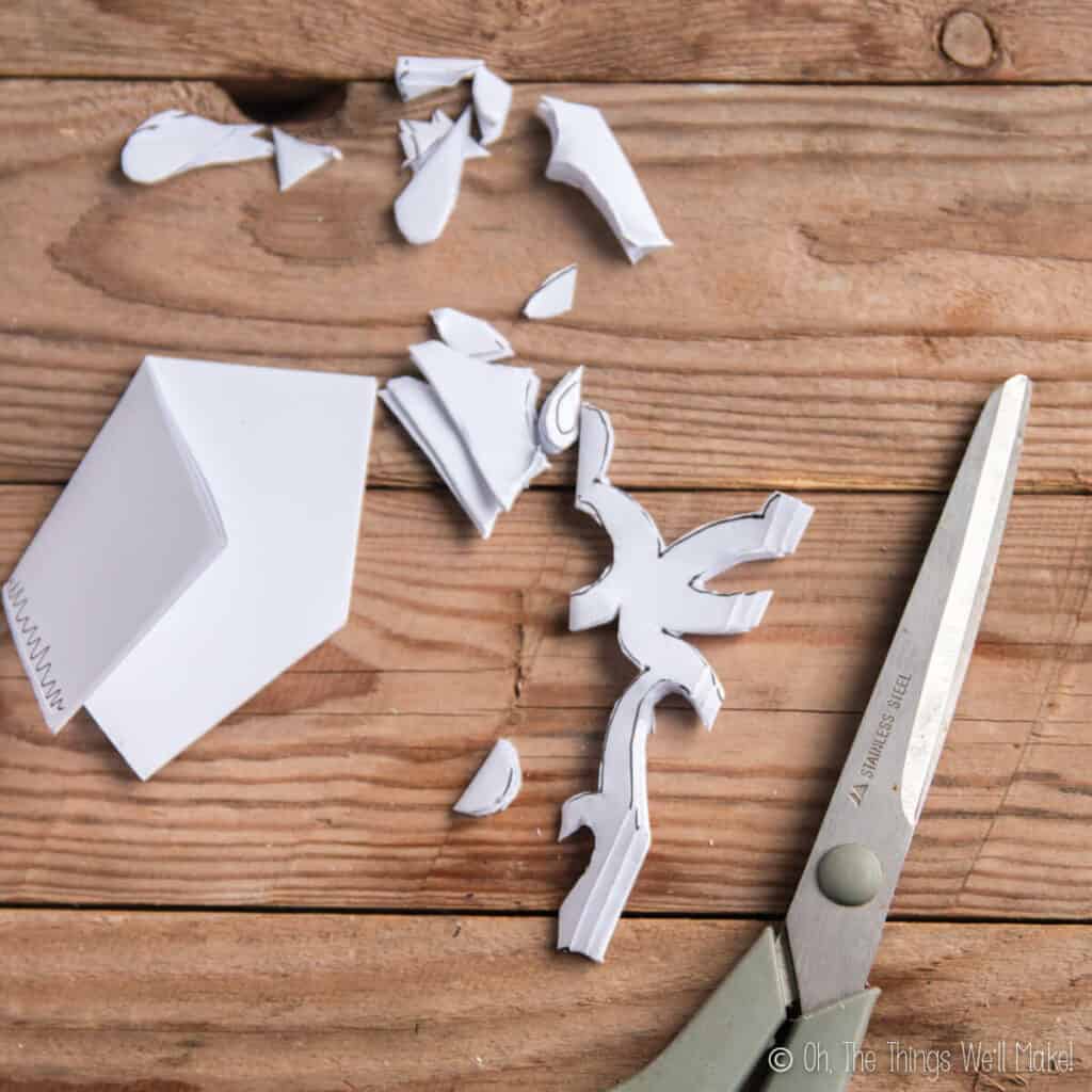 A paper snowflake being cut out from a folded piece of paper.