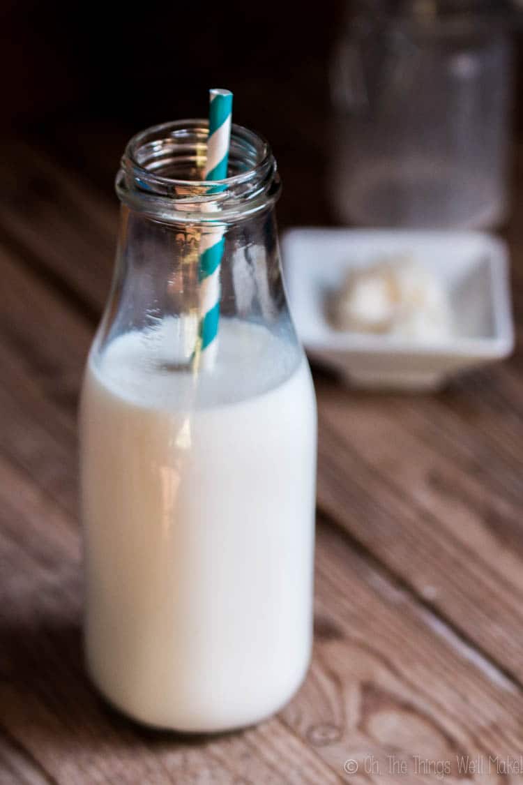 Een close-up van een fles melkkefir met een papieren rietje