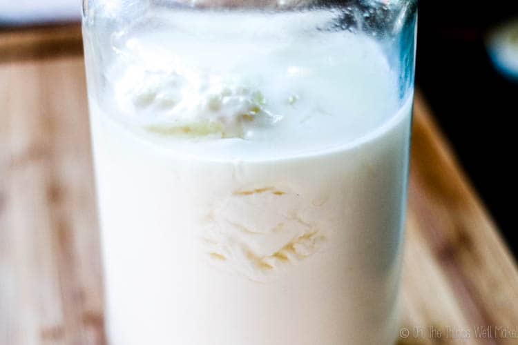 A jar of kefir where you can see the curds and whey separating.