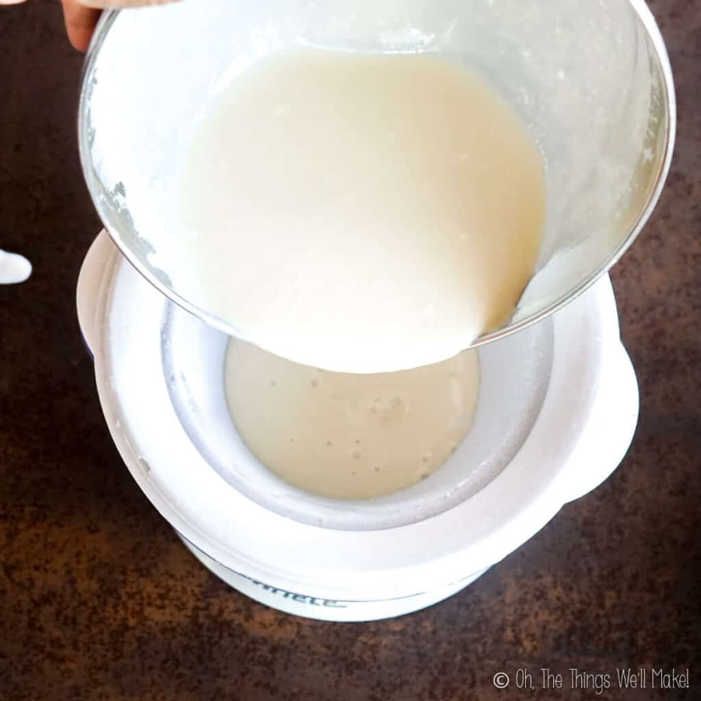 Pouring a cream custard mixture into a frozen container for making ice cream.