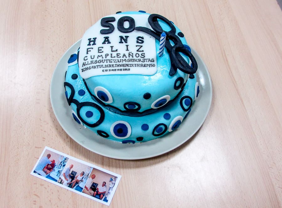 Overhead view of a finished fondant optometrist cake next to some photos of an optometrist helping friends. 