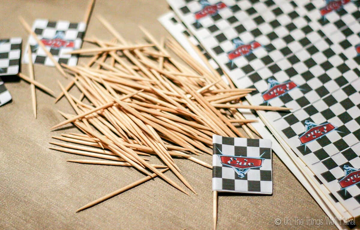 Mini flags made by folding sticker's with a checkerboard pattern over toothpicks.