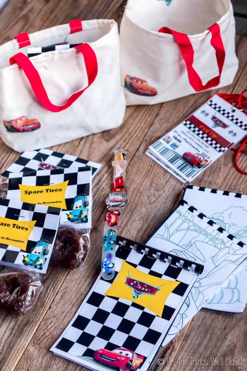 Cars party favors- including small cloth tote bags filled with donut "spare tires", Cars themed watches, and small coloring books with a Cars theme.