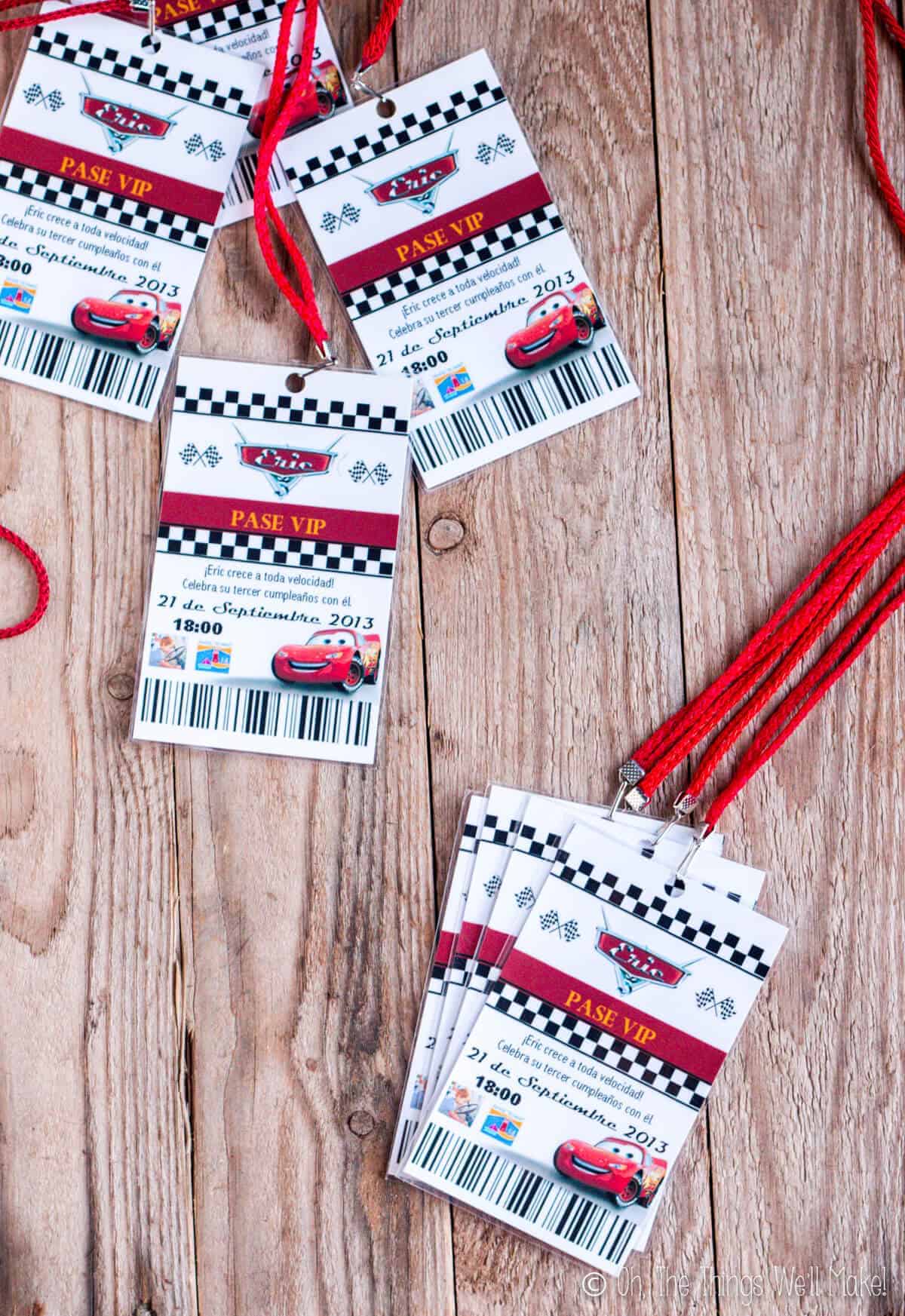 Several Cars themed invitations that look like pit passes on red lanyards.