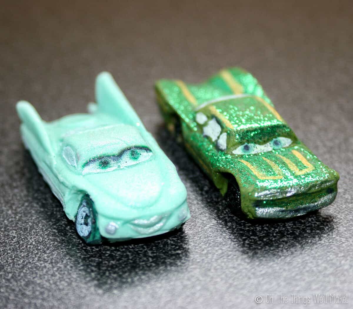 Close up of two fondant car decors: turquoise Flo and glittery green Ramone.