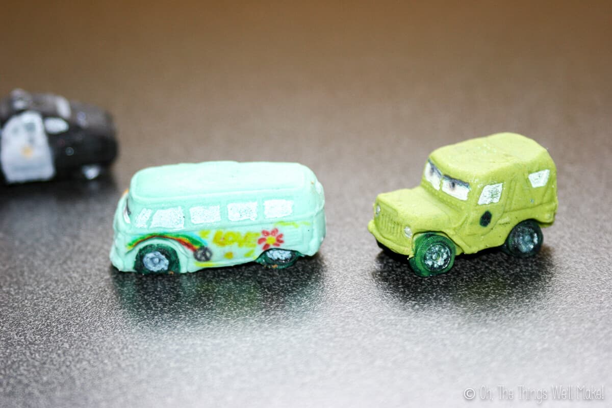 Close up of two fondant car decors: turquoise Fillmore and green Sarge.