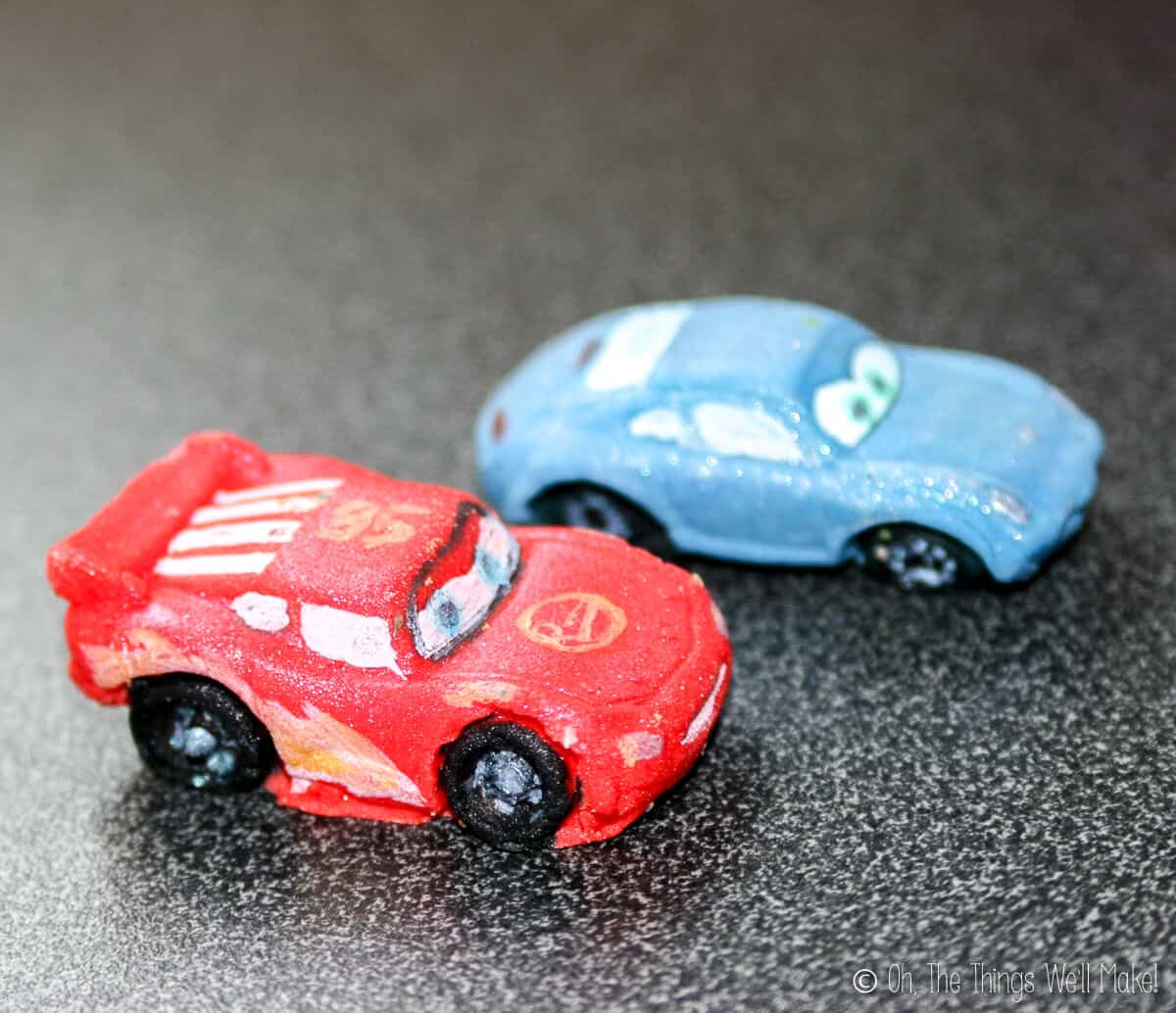 Blue Sally and red Lightning McQueen cars made from fondant.