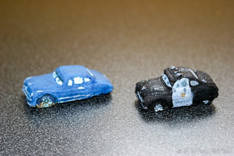 Close up of two fondant car decors: blue Doc Hudson and black Sheriff