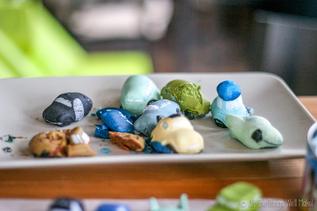 Close up of white plate full of fondant cars that have puffed out and deformed in shape