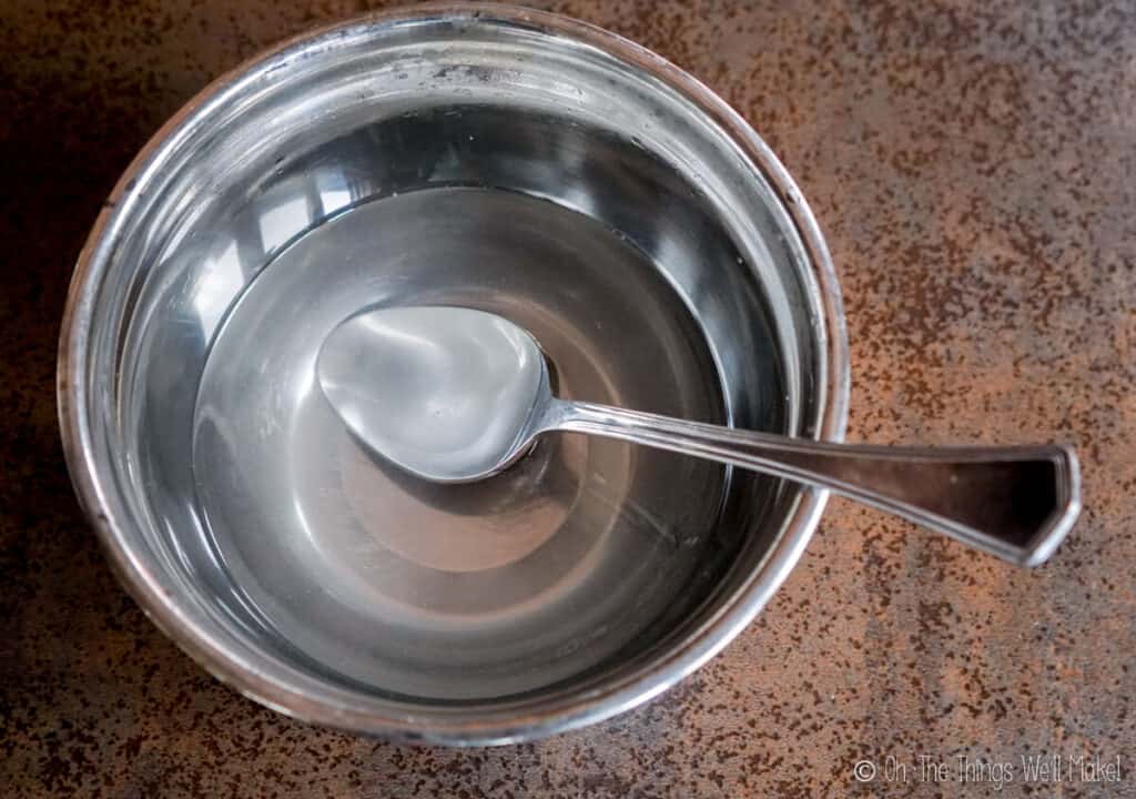 A stainless steel bowl filled with a lye solution.