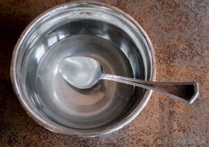 A stainless steel bowl filled with a lye solution.