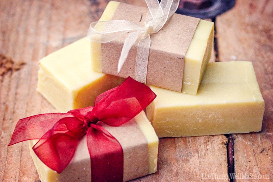 a stack of homemade soaps, two of which have been wrapped in brown paper and ribbons