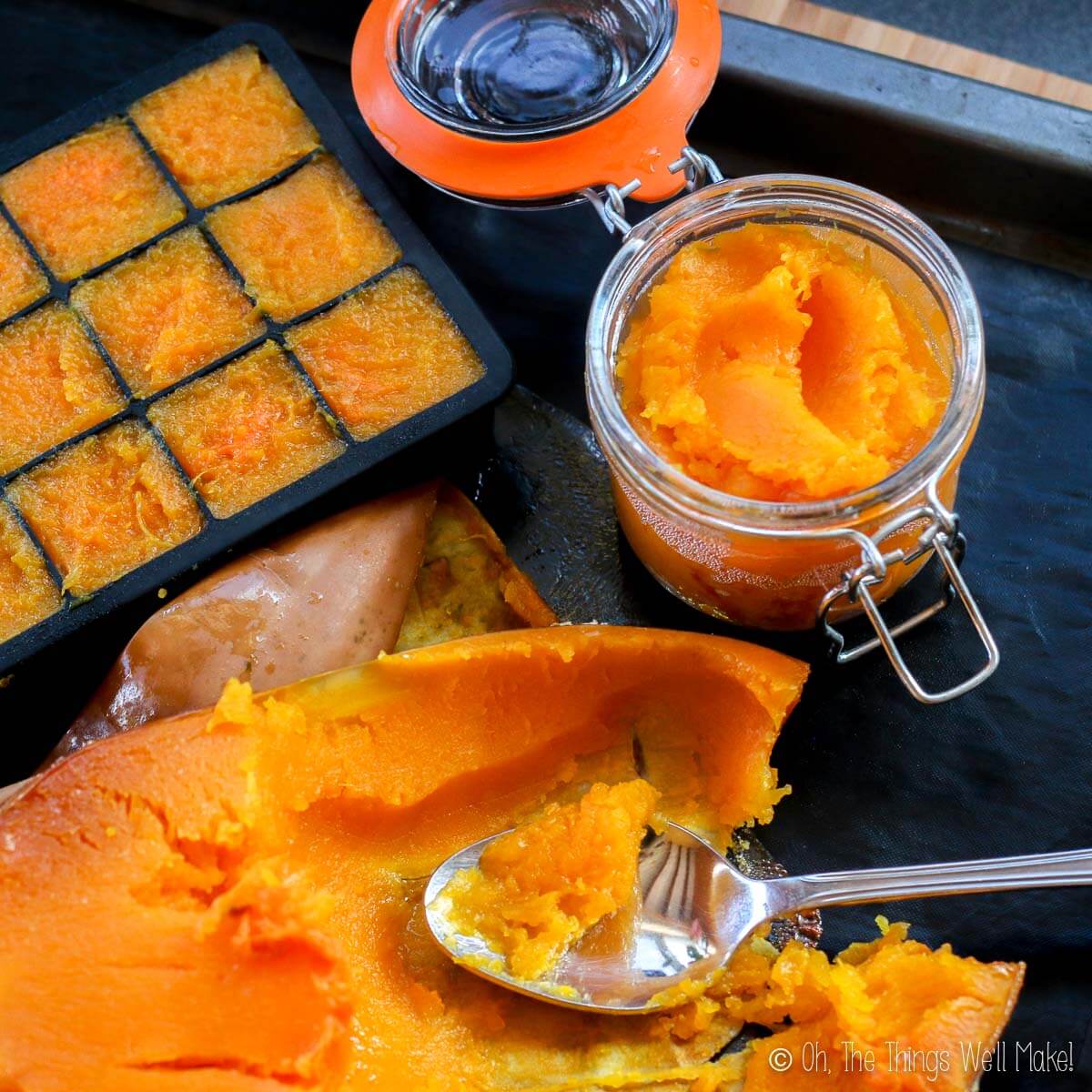 Overhead view of scooping out a roasted butternut squash pumpkin into a jar and ice cube trays for freezing.