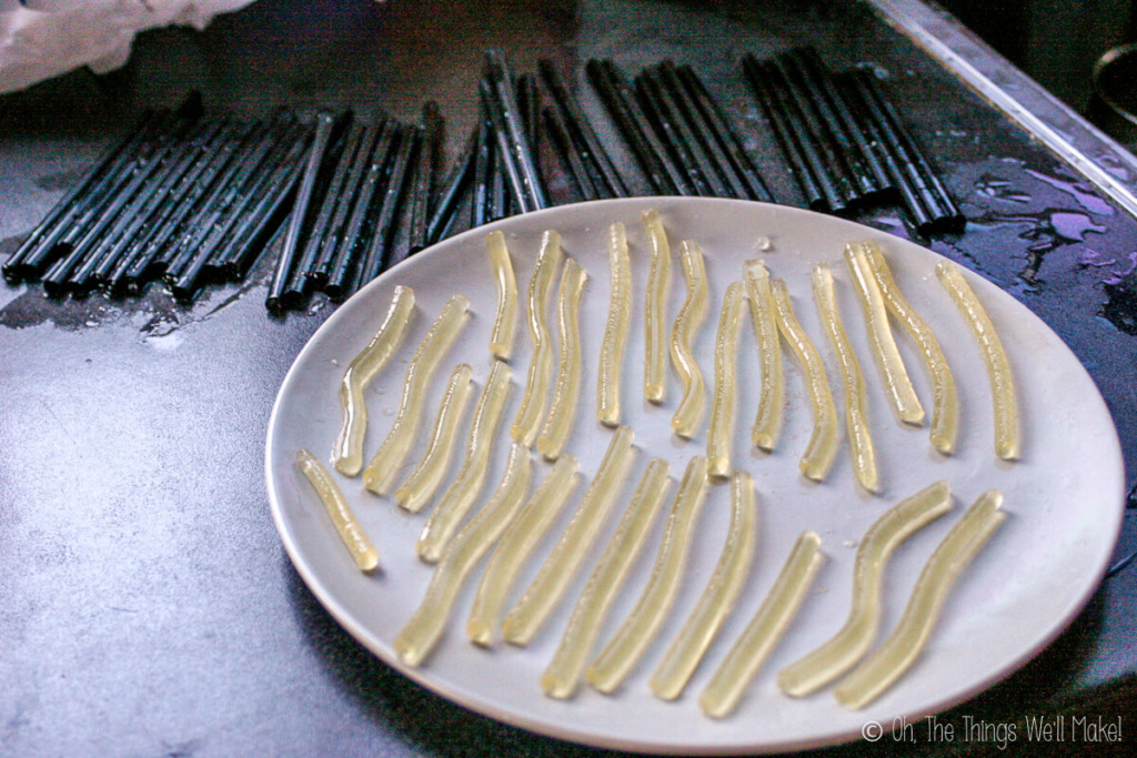 A plate full of worms in front of a bunch of empty straws