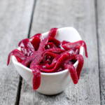 Close up of a bowl full of red homemade gummy worms (leeches).