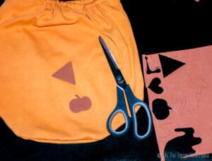 Cutting a triangle and Halloween themed shapes from craft foam to make fabric stamps