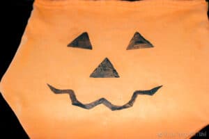 stamping a Jack-o-lantern face onto our homemade trick-or-treat bag