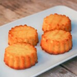 Four mini tartas de Santiago, baked in silicone muffin molds, on a plate