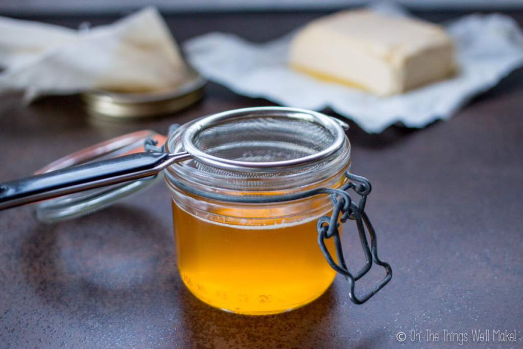 a jar of melted ghee in front of a block of butter