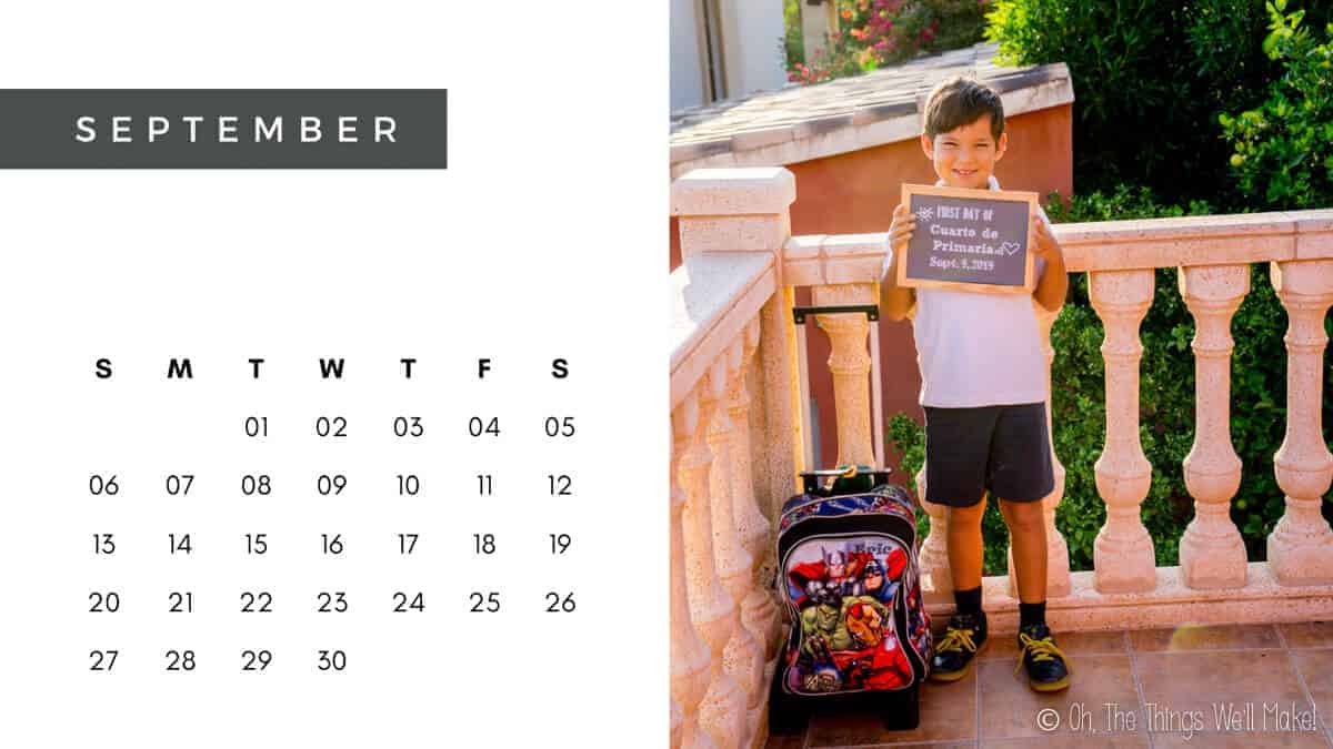 A September calendar with a photo of a boy holding a sign announcing the first day of school