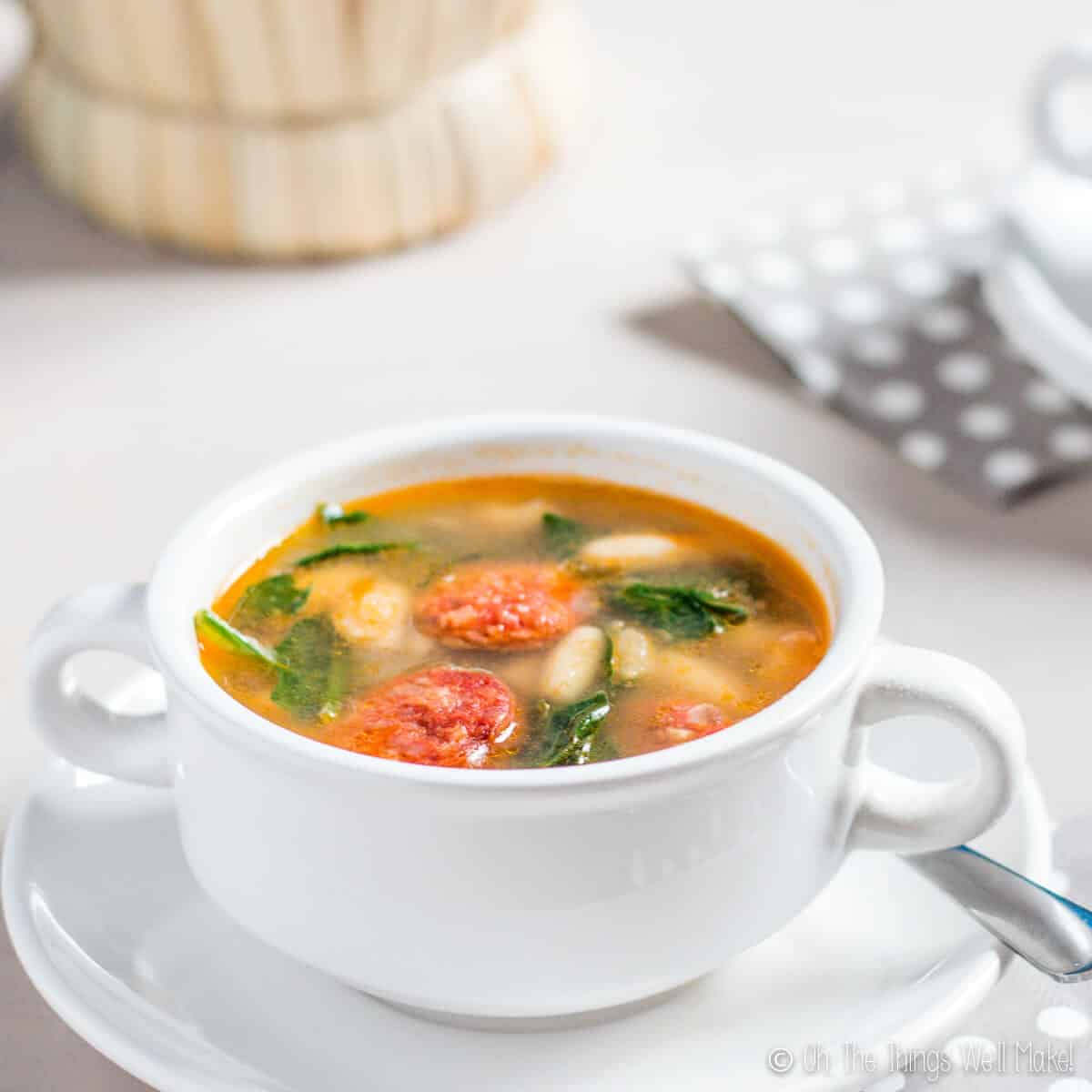 An overhead view of a bowl of white bean and chorizo soup with spinach