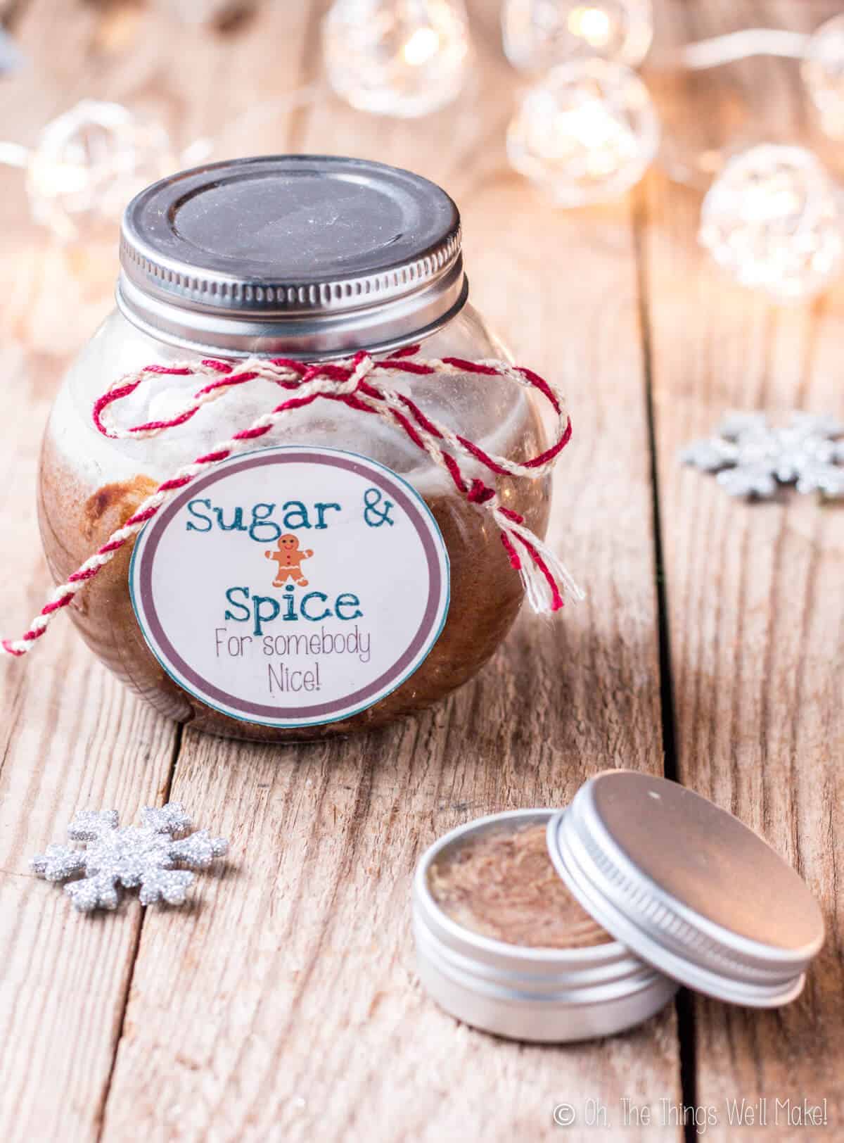 Closeup of a homemade sugar body scrub with a smaller tin of a lip scrub in front.