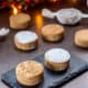 An assortment of homemade mantecados and polvorones on a black slate plate.