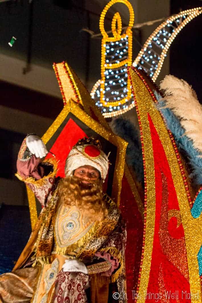 Gaspar, Wise man of India, throwing candy to children eagerly awaiting them in a parade in Spain