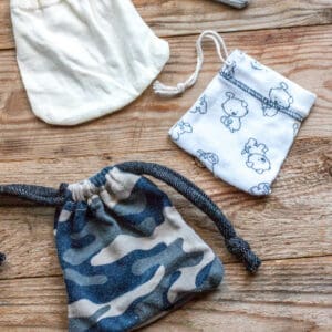 Top view of 3 drawstring pouches made from the sleeves of baby clothes.
