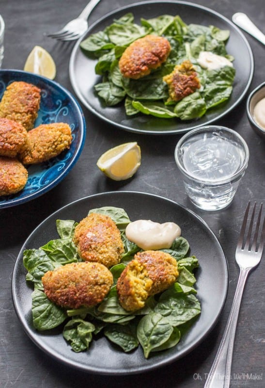 healthy bean recipes -- turmeric falafel on plates of spinach from Oh, the things we'll make!