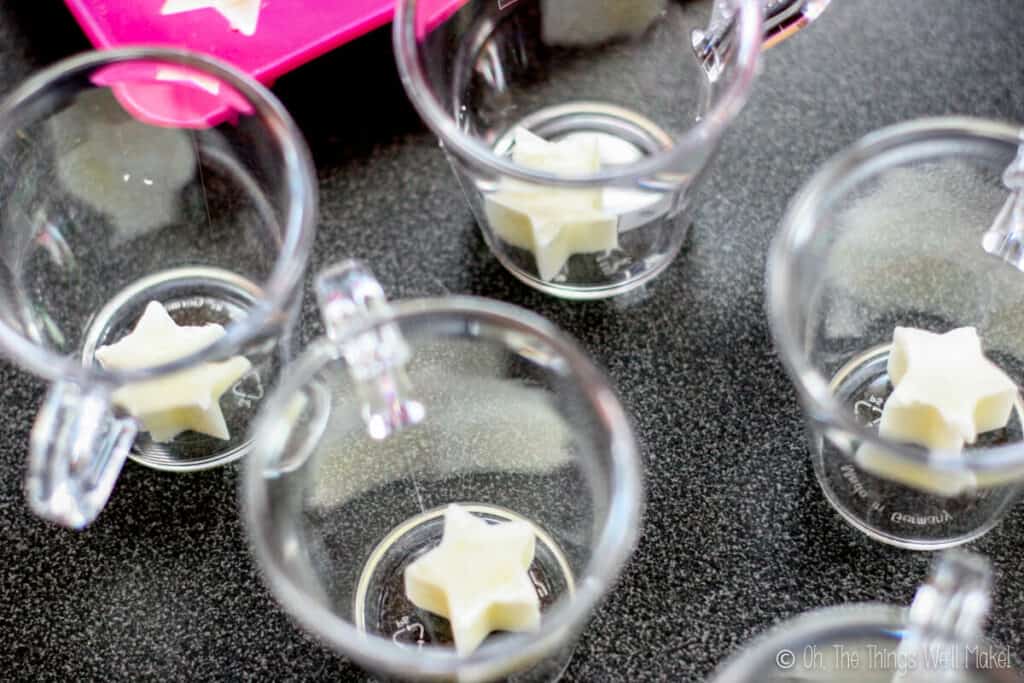 White star-shaped ice cubes in the bottom of flat bottomed cups