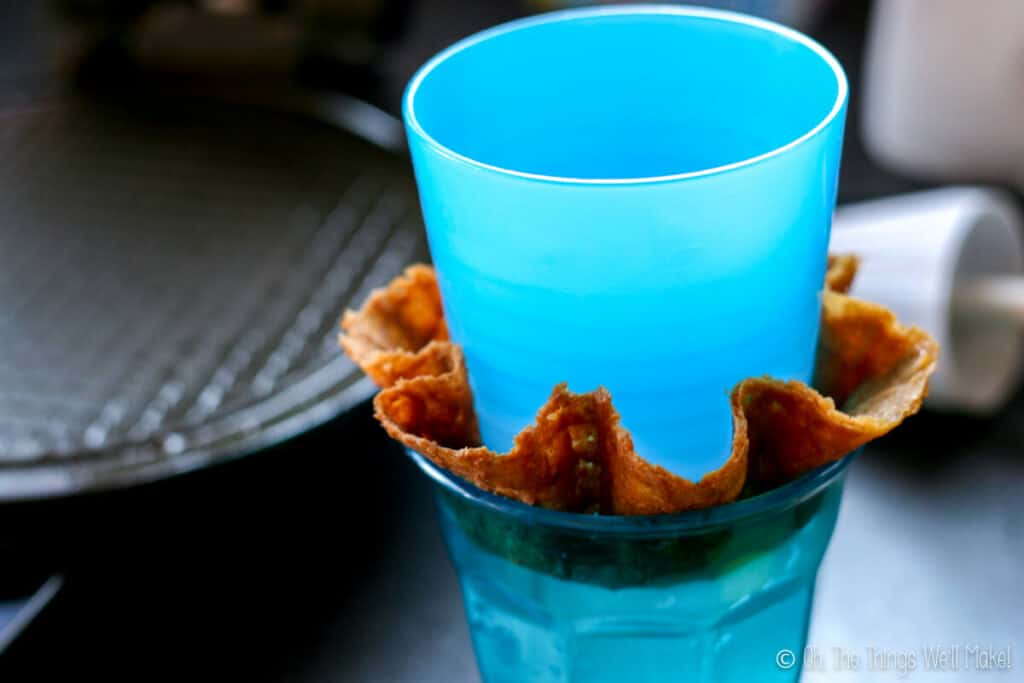 forming a homemade waffle bowl by pressing a thin waffle cookie between two cups.