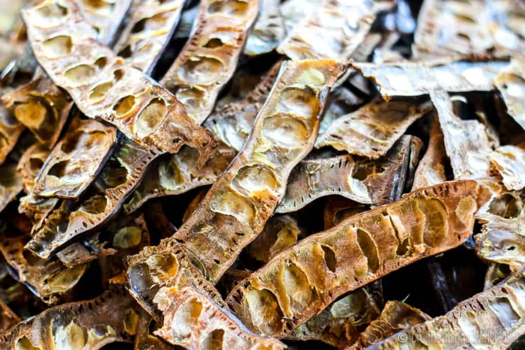 Carob pods that have been sliced in half, with the seeds removed