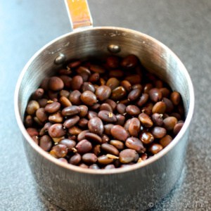 Carob seeds in a measuring cup