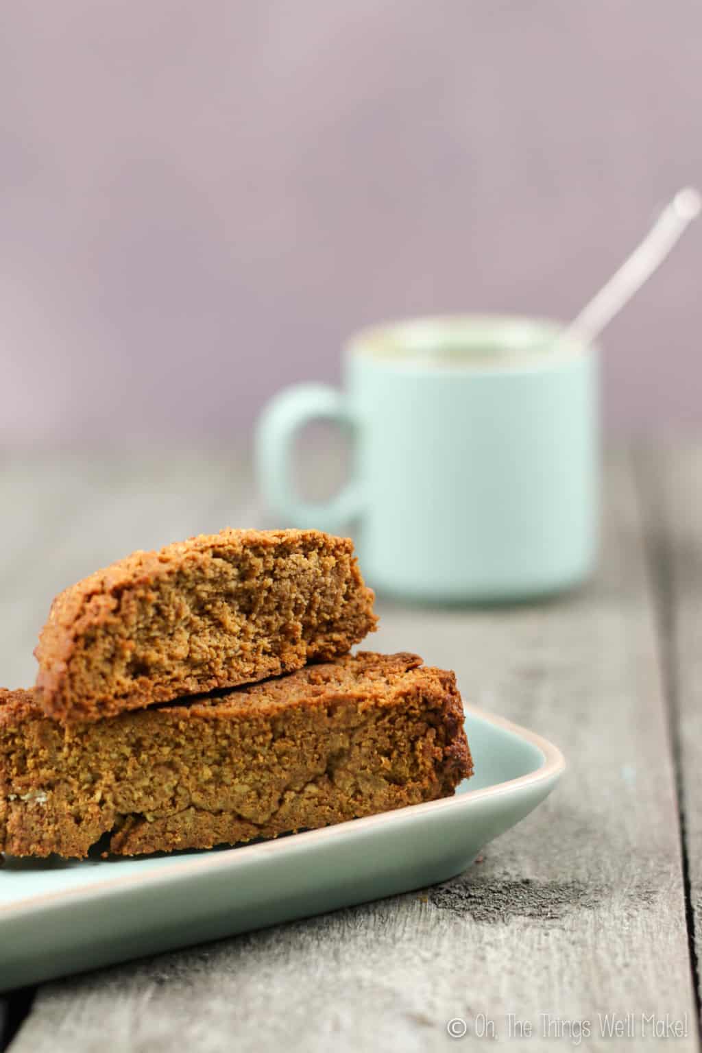 My original pumpkin spice biscotti on a plate in front of a light turquoise cup of coffee.