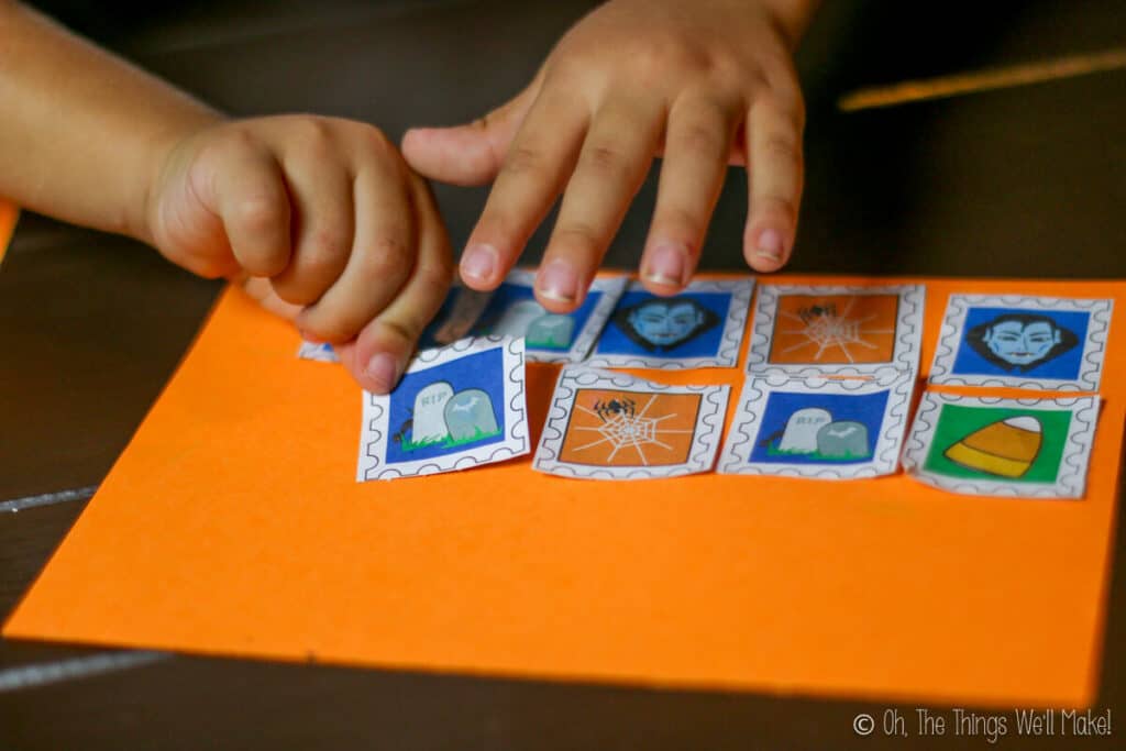 sticking down several homemade Halloween postage stamps