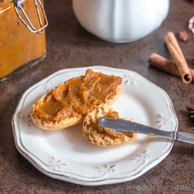 spreading pumpkin butter on two toasts on a plate